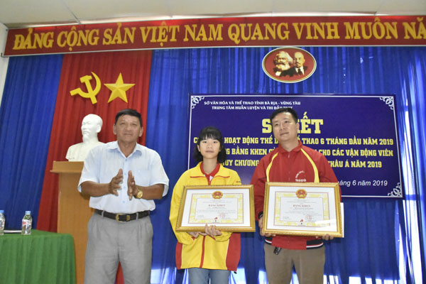 Ông Đặng Văn Cường, Giám đốc Trung tâm Huấn luyện và thi đấu TDTT tỉnh trao Bằng khen của Chủ tịch UBND tỉnh cho VĐV Nghiêm Thảo Tâm và HLV Phùng Nguyên Tường Minh, đội tuyển cờ vua tỉnh BR-VT.