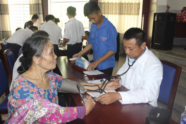 Thiếu tá Cao Văn Dược, y sĩ Trung đoàn Tên lửa E261 khám bệnh cho bà Trần Thị Thể (ấp 6, xã Hòa Bình, huyện Xuyên Mộc).