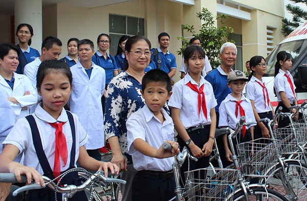 Đại diện International SOS tặng xe đạp cho học sinh.