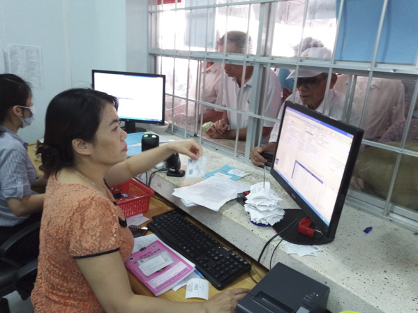 Hiện nay, nơi chờ khám, chữa bệnh tại Bệnh viện Lê Lợi chật hẹp, nóng bức rất vất vả, bệnh nhân quá đông. Cử tri đề nghị UBND tỉnh có giải pháp khắc phục tình trạng trên. Trong ảnh: Nhân viên y tế làm thủ tục khám, chữa bệnh cho bệnh nhân tại Bệnh viện Lê Lợi.