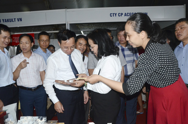 Bà Nguyễn Thị Chim Lang (giữa), Chủ tịch HĐQT Công ty TNHH Nông nghiệp công nghệ cao Vũng Tàu giới thiệu sản phẩm chocolate cho khách mời tại Hội chợ triển lãm sản phẩm công nghiệp nông thôn tiêu biểu khu vực phía Nam. Ảnh: ĐÔNG HIẾU