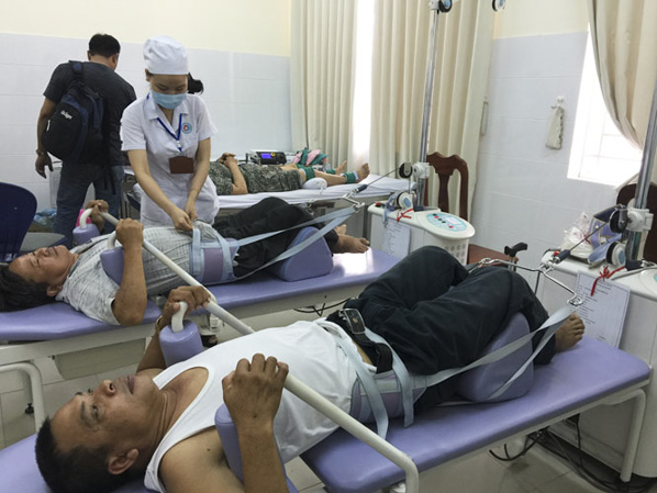Bệnh nhân được cán bộ y tế chăm sóc, theo dõi quá trình trị liệu bằng máy kéo giãn tại BV Y học Cổ tuyền tỉnh.  
