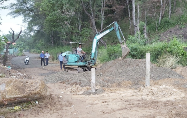 Lực lượng chức năng dùng máy ủi san gạt phần xà bần, đá dăm trên con đường mà bà Trần Thị Cẩm Nhung tự ý làm.