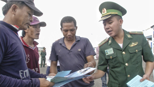Lực lượng Bộ đội Biên phòng tỉnh tuyên truyền, phát tờ rơi cho ngư dân TP.Vũng Tàu các nội dung liên quan tới quy định pháp luật về khai thác hải sản xa bờ, phòng chống ma túy.  Ảnh: PHƯƠNG NAM