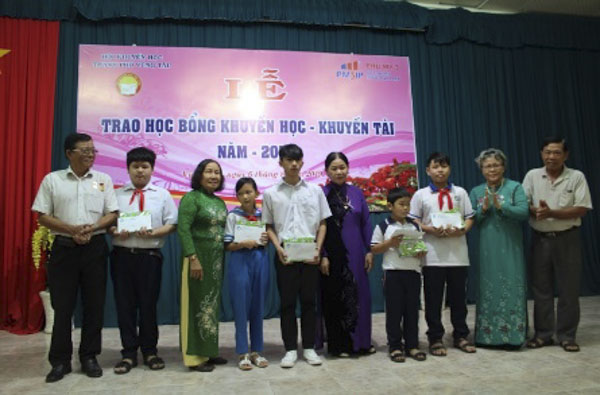 Các nhà tài trợ trao học bổng cho 5 học sinh con liệt sĩ và bộ đội Hải quân đang công tác ở đảo Trường Sa. Ảnh: NGUYỄN HẠ