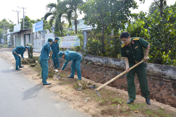 Cán bộ, chiến sĩ LLVT tỉnh làm vệ sinh đường giao thông liên xã.
