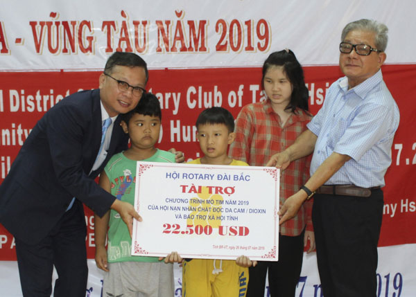 Ông Nguyễn Văn Nhân, Chủ tịch Hội Nạn nhân CĐDC/dioxin và Bảo trợ xã hội tỉnh tiếp nhận tài trợ mổ tim cho trẻ em bị nhiễm CĐDC từ đại diện Hội Rotary tín nghĩa Đài Bắc (bên trái).
