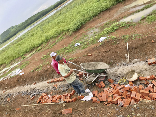Công nhân xây dựng hàng rào bao quanh khu đất gần mé hồ Đá Bàng.