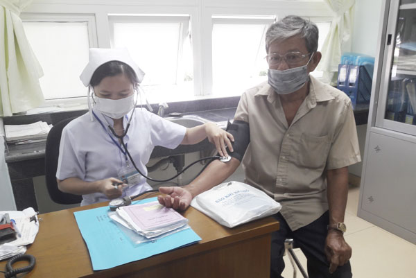 Những người tiếp xúc với gia cầm mắc bệnh, khi có các triệu chứng: sốt đột ngột; ho, đau họng, viêm long đường hô hấp hoặc khó thở, đau ngực, cần nghĩ ngay đến cúm A/H5N6. Trong ảnh: Nhân viên y tế Bệnh viện Bà Rịa kiểm tra cho bệnh nhân.