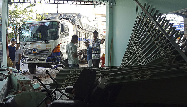 Xe tải tông sập cửa kéo và bức tường của tiệm cắt tóc.