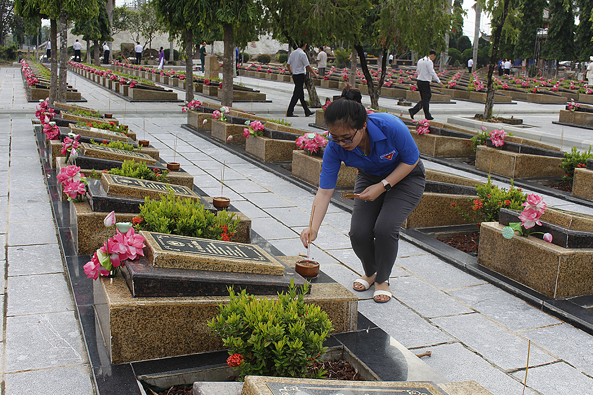Thanh niên thắp nhang tại các phần mộ liệt sĩ. 
