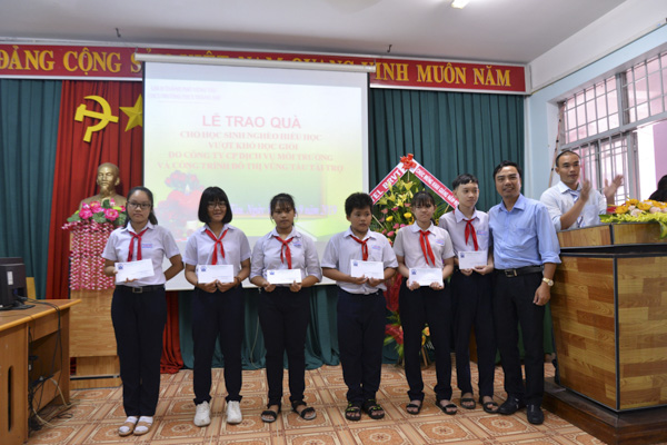 Đại diện Công ty CP Dịch vụ môi trường và Công trình đô thị Vũng Tàu trao quà cho HS trường THCS Thắng Nhì