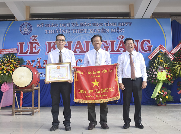 Ông Nguyễn Văn Xinh, Ủy viên Ban Thường vụ Tỉnh ủy, Trưởng Ban Tuyên giáo Tỉnh ủy (bìa phải) trao Cờ thi đua xuất sắc năm học 2018-2019 của UBND tỉnh cho Trường THPT Xuyên Mộc.