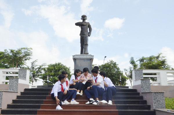 Cô Võ Thị Kim Liên, Tổng Phụ trách Đội Trường THCS Dương Văn Mạnh và các em HS trao đổi về AHLS Dương Văn Mạnh tại tượng đài mang tên ông.