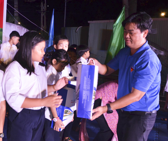 Anh Lê Văn Minh, Bí thư Tỉnh Đoàn trao quà cho thiếu nhi sống tại bãi rác Tóc Tiên, TX. Phú Mỹ trong chương trình 