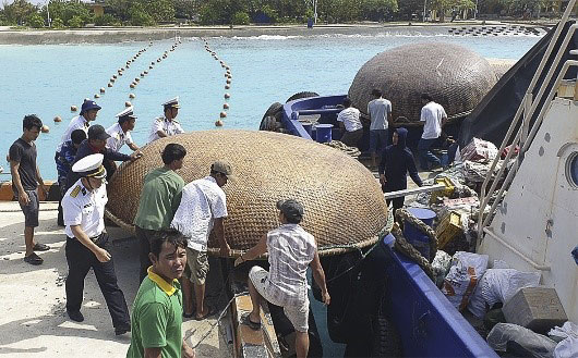 Cán bộ, nhân viên Trung tâm Hậu cần-Kỹ thuật đảo Sinh Tồn và ngư dân chuyển ngư cụ của tàu cá QNg 95834 TS lên tàu KN 410.