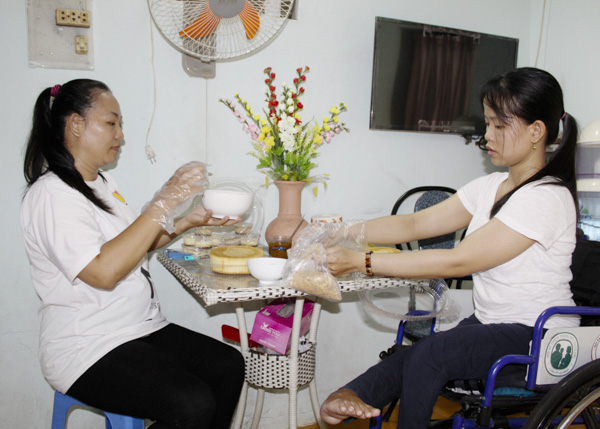 Nhờ học lớp dạy nghề làm bánh miễn phí do Hội NNCĐDC và BTXH tỉnh tổ chức,  chị Trương Thị Thùy (bên phải) có thu nhập khoảng 150-200 ngàn đồng/ngày.