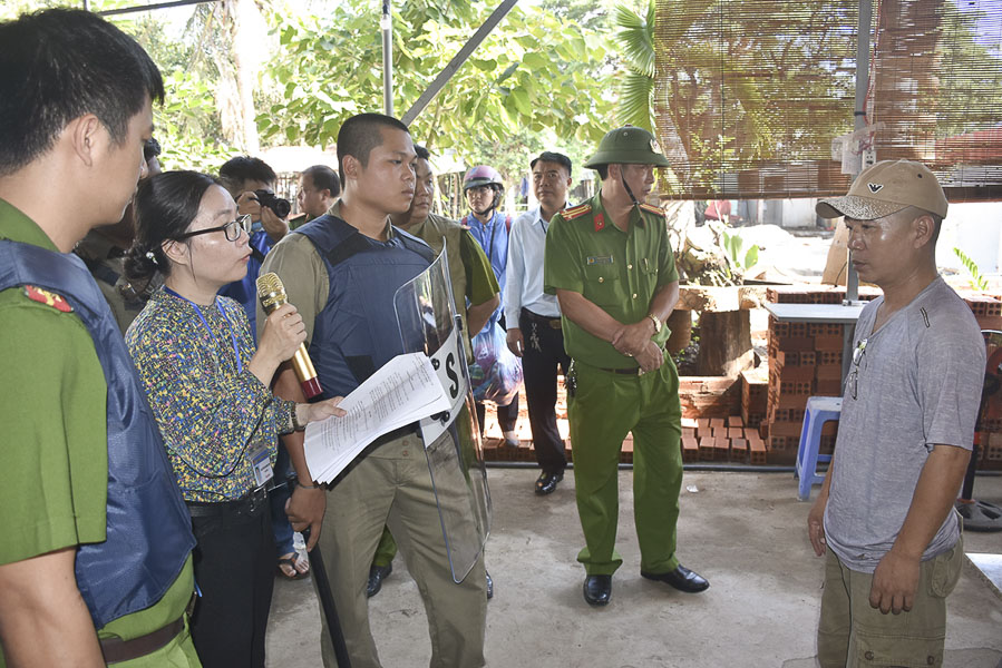 Lãnh đạo Phường 9 đọc quyết định cưỡng chế đối với trường hợp ông Vũ Quốc Hưng (bìa phải).