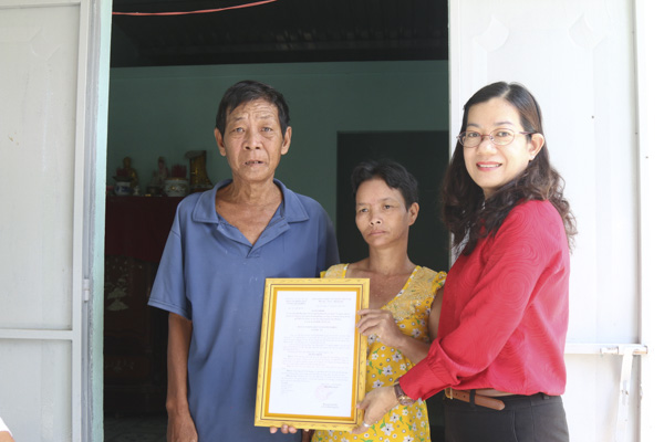 Bà Nguyễn Thị Cẩm Yến, Chủ tịch UBMTTQ Việt Nam huyện Đất Đỏ trao Quyết định bàn giao nhà cho gia đình ông Nguyễn Văn Hoàng (xã Lộc An).