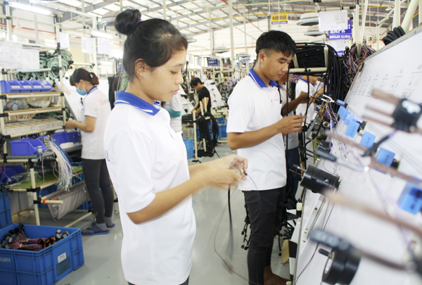 Trong thời gian qua, mặc dù gặp không ít khó khăn nhưng nhiều DN đã mạnh dạn tăng vốn đầu tư, mở rộng sản xuất. Trong ảnh: Công nhân Công ty TNHH Dongjin Global (KCN Đất Đỏ 1, huyện Đất Đỏ) sản xuất cáp điện ô tô xuất khẩu. 