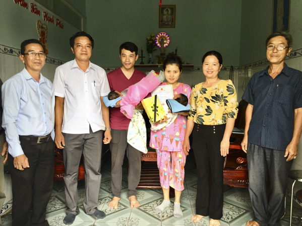 Đại diện chính quyền huyện Châu Đức tặng hoa chúc mừng và trao Giấy khai sinh cho 2 con của ông Phùng Thái Hòa.