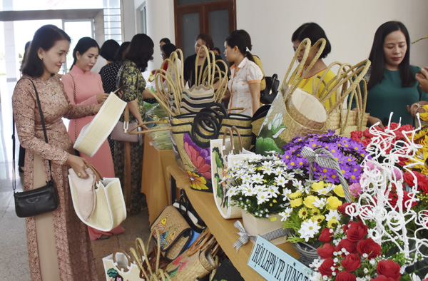 Các đại biểu tham quan và chọn mua giỏ xách, ba lô bằng cói do Hội LHPN TP.Vũng Tàu trưng bày tại buổi họp mặt.