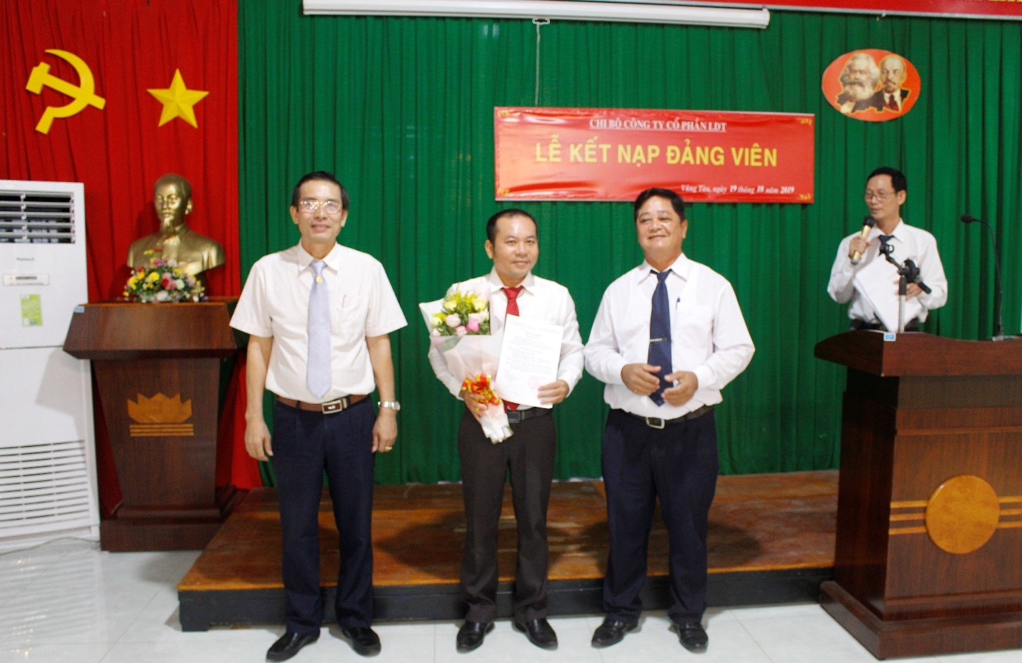 Ông Từ Văn Hoàng (bên phải), Bí thư Chi bộ và ông Võ Minh Giang (bên trái), Phó Bí thư Đảng ủy Khối Cơ quan và DN tỉnh trao Quyết định kết nạp Đảng và tặng hoa chúc mừng ông Lê Duy Thặng.