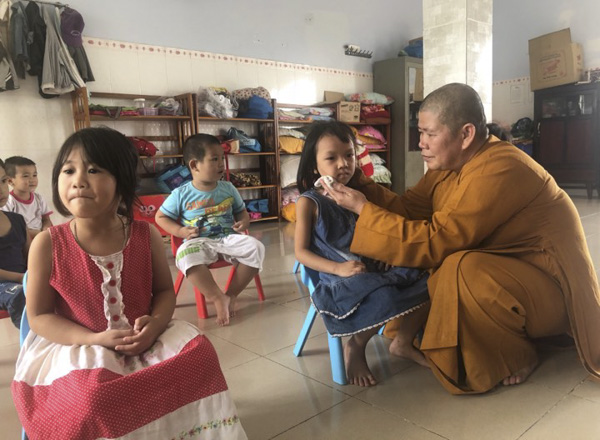 Ni sư Thích Nữ Tiến Liên chăm sóc các cháu được nuôi dưỡng tại Trung tâm Bảo trợ xã hội Tịnh xá Ngọc Đức.