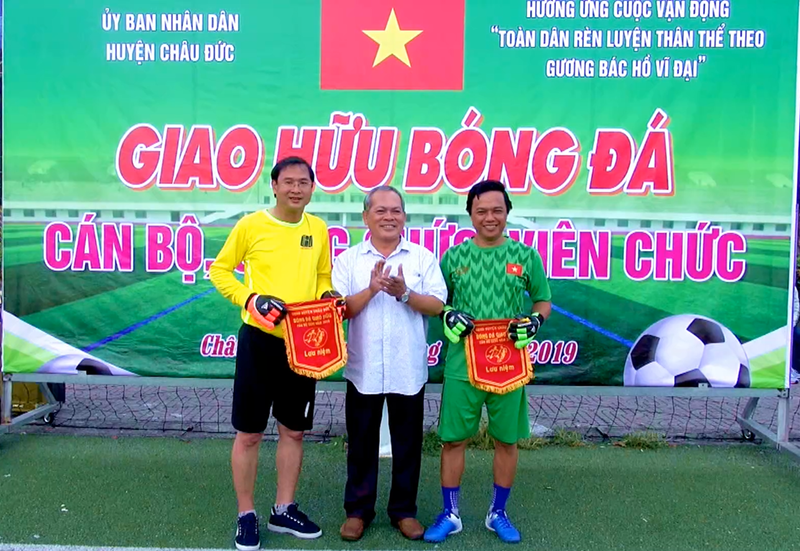Ông Nguyễn Văn Thu (đứng giữa) trao Cờ lưu niệm cho đại diện 2 đội bóng.