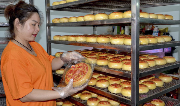 Chị Văn Mỹ Linh kiểm tra bánh da dộp trước khi đóng gói.