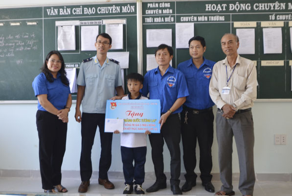 Đại diện Cụm thi đua số 5 trao học bổng “Nâng bước tương lai” cho em Trần Huy Hoàng.