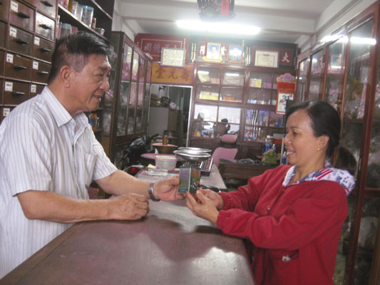 Lương y Ngô Tín Cường hướng dẫn sử dụng thuốc cho bệnh nhân. 