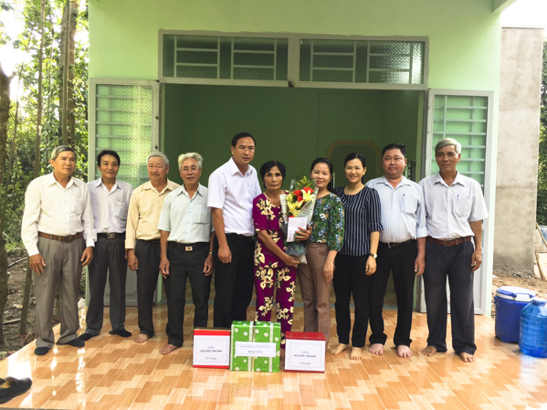 Đại diện lãnh đạo huyện Châu Đức và xã Xà Bang trao quà trong lễ bàn giao nhà Đại đoàn kết cho bà Mai Thị Quýt. 
