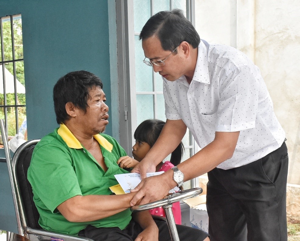 Ông Nguyễn Tấn Bản, Phó Chủ tịch UBND huyện Châu Đức trao quà cho ông Dương Văn Lộc.