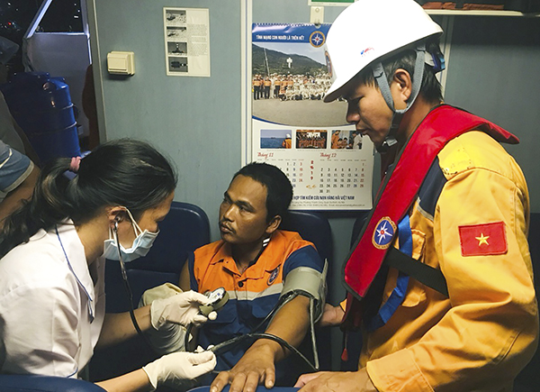 Lực lượng cứu nạn và bác sĩ sơ cứu ngư dân Danh Sáng trên tàu cá. 