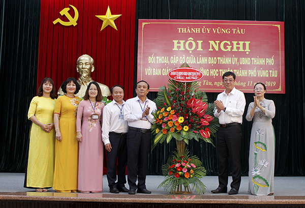 Ông Trần Đình Khoa (thứ hai từ phải qua), Ủy viên Ban Thường vụ Tỉnh ủy, Bí thư Thành ủy Vũng Tàu và bà Nguyễn Thị Thu Hương (bìa phải), Phó Chủ tịch UBND TP.Vũng Tàu tặng hoa chúc mừng các thầy, cô giáo nhân dịp Ngày Nhà giáo Việt Nam 20/11.