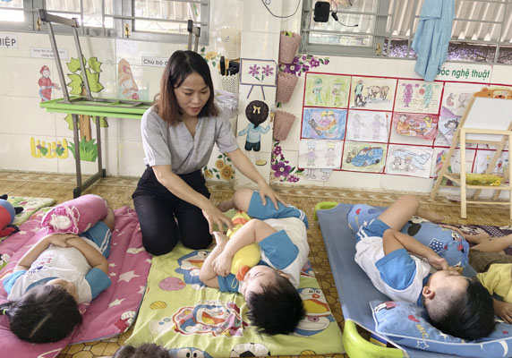 Cô Nguyễn Nữ Thu Thủy, Tổ trưởng Tổ Mẫu giáo Trường MN 1/6 (huyện Xuyên Mộc) dỗ dành trẻ trước giờ ngủ trưa.