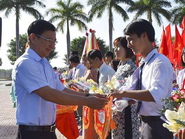 Ông Nguyễn Hòa Hiệp, Phó Chủ tịch HĐND huyện tặng hoa và cờ lưu niệm cho các đơn vị dự Hội khỏe Phù Đổng huyện Đất Đỏ năm 2019.