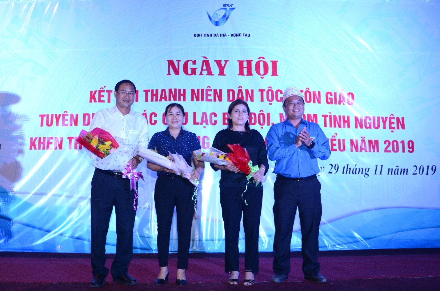 Anh Nguyễn Minh Triết (bìa phải), Chủ tịch Hội LHTN Việt Nam tỉnh trao tặng hoa cho ông Nguyễn Tấn Bản (bìa trái), Phó Chủ tịch UBND huyện Châu Đức và Chủ nhiệm Nhà Văn hóa dân tộc Bàu Chinh.
