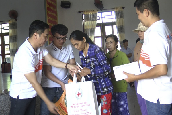 Nhóm tài trợ EMS và những người bạn tặng quà cho hộ nghèo xã Hòa Hội. Ảnh: NGUYỄN THẮNG