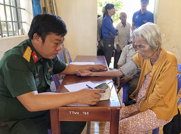 Đại tá Nguyễn Hoàng Tấn, Phó Chính ủy Bộ CHQS tỉnh tặng quà cho các hộ dân có hoàn cảnh khó khăn trên địa bàn xã Phước Tân.