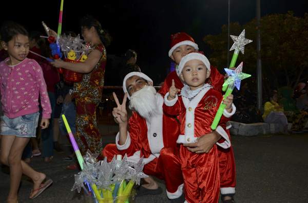 Ông già Noel tạo dáng xì tin cùng các em nhỏ. Ảnh: THANH HƯỜNG