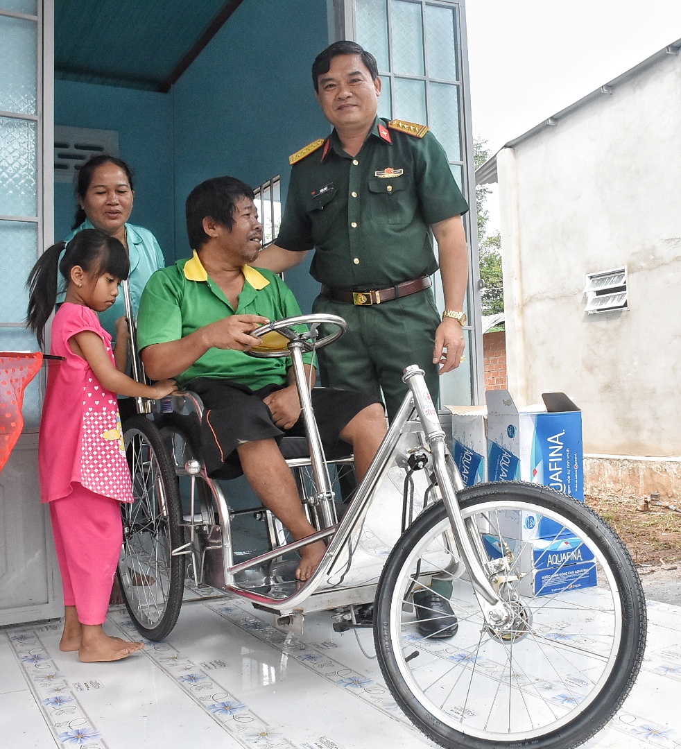 Đại tá Phạm Phú Ý, Ủy viên Ban Thường vụ Tỉnh ủy, Chỉ huy trưởng Bộ CHQS tỉnh trao chiếc xe lăn và bàn giao nhà cho ông Dương Văn Lộc (thôn Lồ Ồ, xã Đá Bạc, huyện Châu Đức).