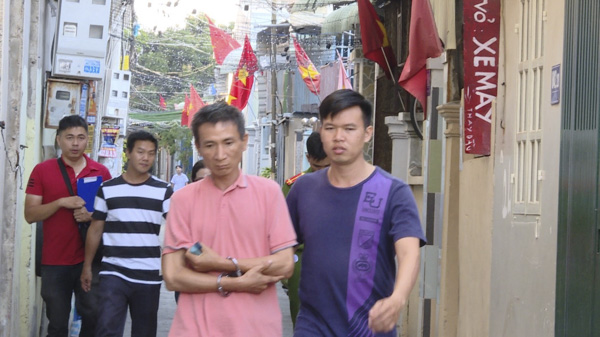Sơn bị lực lượng chức năng dẫn giải đến thực nghiệm hiện trường. 