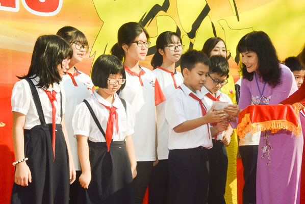 Bà Nguyễn Thị Kỷ, Giám đốc Thư viện TP. Vũng Tàu tặng thẻ thư viện cho HS. 