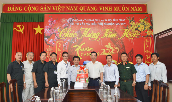 Ông Lưu Tài Đoàn (thứ 5 từ phải qua) tặng quà cho đại diện Cơ sở Tư vấn và Điều trị nghiện ma túy. Ảnh: MINH THANH