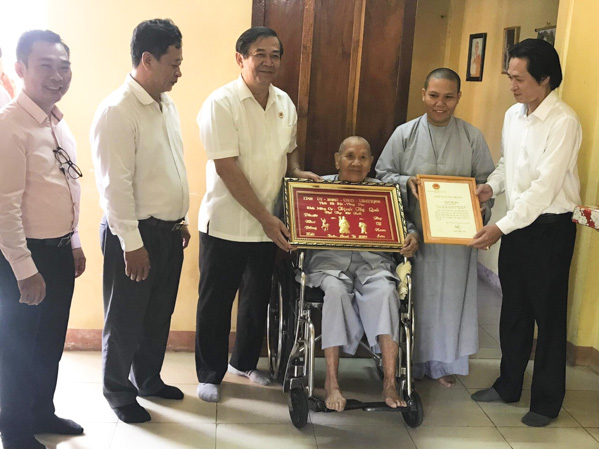  Ông Mã Thành Sơn, Chủ tịch Hội Cựu Chiến binh tỉnh (thứ 3 từ trái sang) tặng quà cho cụ Trịnh Thị Quả (phường Phú Mỹ, TX. Phú Mỹ). Ảnh: MINH NHÂN