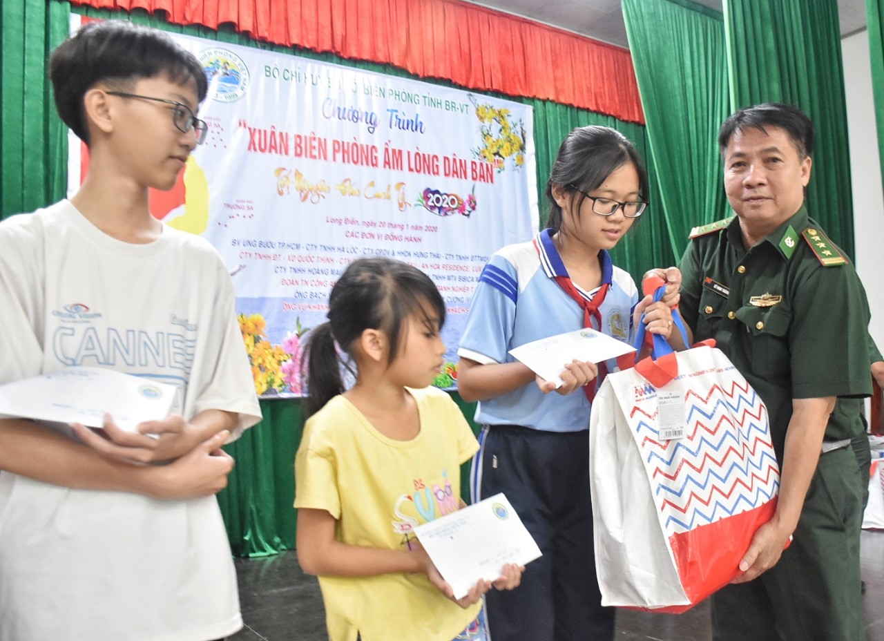 Thượng tá Lê Vinh Thành, Đồn trưởng Đồn Biên phòng Phước Tỉnh trao quà cho HS nghèo hiếu học.