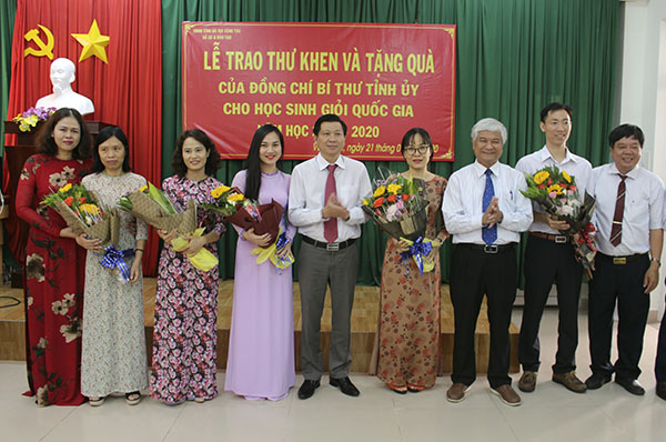 Ông Trần Văn Tuấn, Phó Chủ tịch UBND tỉnh (thứ năm từ phải qua) và ông Nguyễn Thanh Giang, Giám đốc Sở GD-ĐT tặng quà chúc mừng và biểu dương những đóng góp của các GV Trường THPT Chuyên Lê Qúy Đôn trong việc bồi dưỡng, ôn luyện cho các HS đoạt giải.