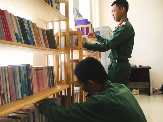 Các chiến sĩ Trung đoàn Minh Đạm xếp sách lên kệ chuẩn bị phục vụ chiến sĩ mới.  Ảnh: KIM LOAN